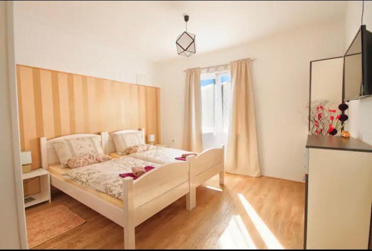 ein Schlafzimmer mit einem weißen Bett und einem Fenster in der Unterkunft Rooms Bobic in Ličko Petrovo Selo