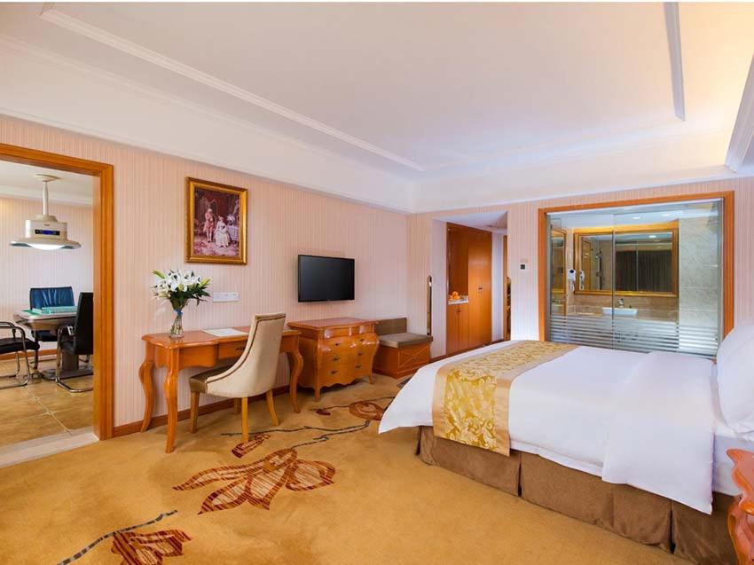 a hotel room with a bed and a desk with a computer at Vienna Hotel Changde Wuling Avenue in Changde