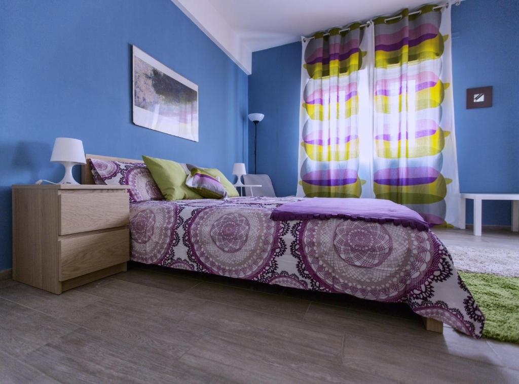 ein Schlafzimmer mit einem lila Bett und blauen Wänden in der Unterkunft Casa Di Amici in Caltanissetta