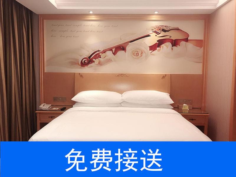 广州维也纳酒店广州番禺南站店的酒店客房的上方设有一张带标志的床