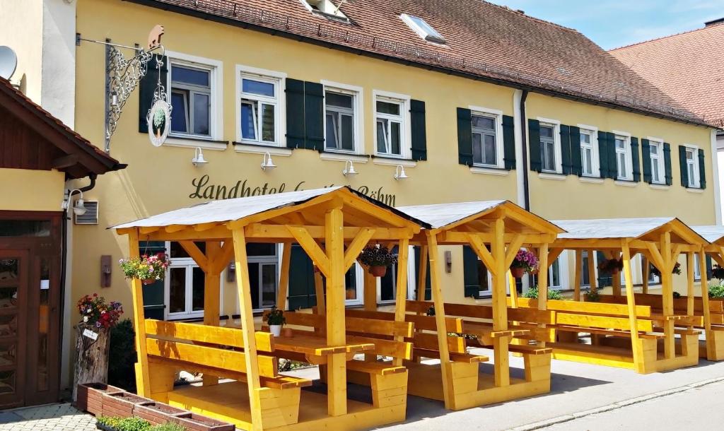 ein Gebäude mit Holzbänken davor in der Unterkunft Landhotel zum Böhm in Roth