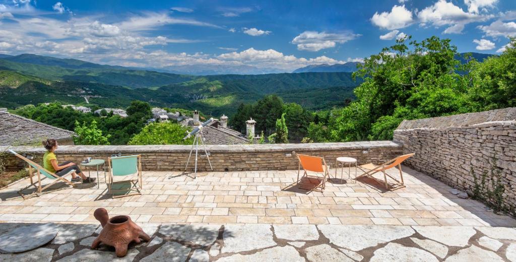a teddy bear sitting on a patio with chairs at The Land Beyond in Vitsa