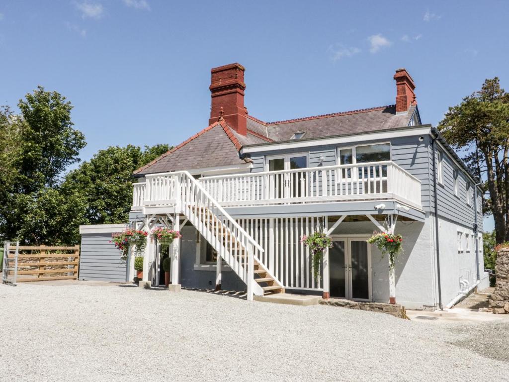 a large white house with a porch and stairs at The Royal Charter Holiday Let in Moelfre