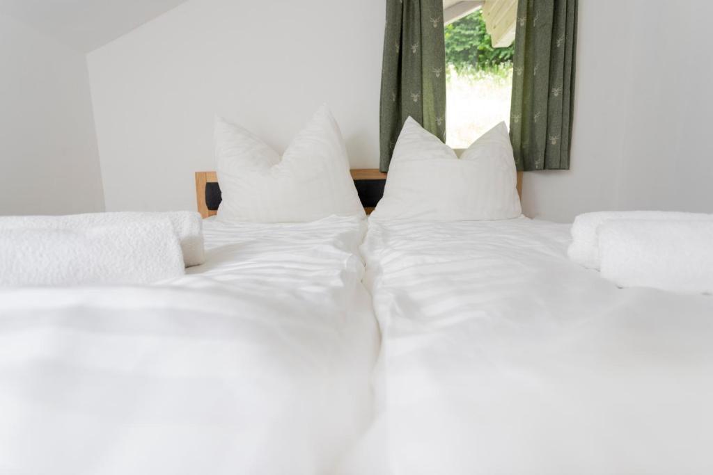 eine Gruppe von drei weißen Kissen auf einem Bett in der Unterkunft Haus Hoen in Untertweng