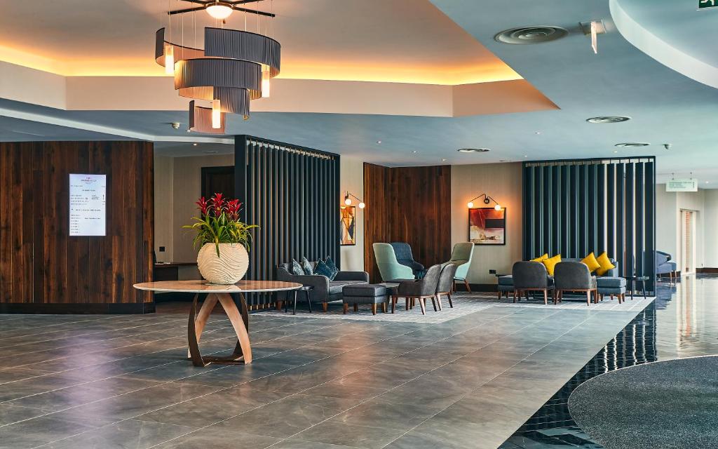 a lobby with a waiting room with a table and chairs at Crowne Plaza Marlow, an IHG Hotel in Marlow