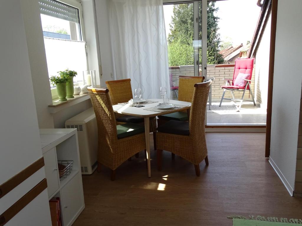 una sala da pranzo con tavolo, sedie e finestra di Ferienwohnung am Lippesee a Paderborn