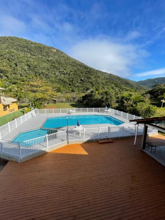 a large swimming pool on a deck with a mountain at Ilha Náutica in Florianópolis