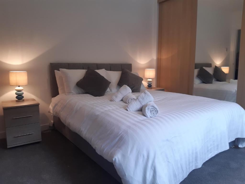 a bedroom with a large white bed with two pillows at Carvetii - Jade House - 3 bed House sleeps up to 8 in Kelty