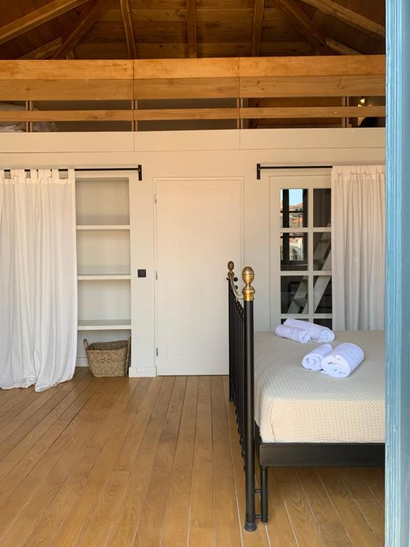 una camera da letto con un letto e un pavimento in legno di 1890 Fanourakis House a Calchi (Halki)