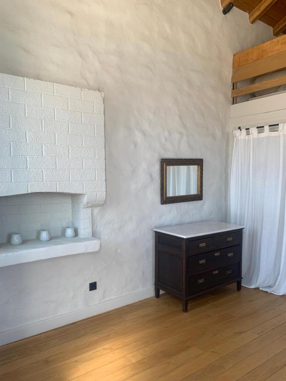 a room with a dresser and a mirror on a wall at 1890 Fanourakis House in Halki