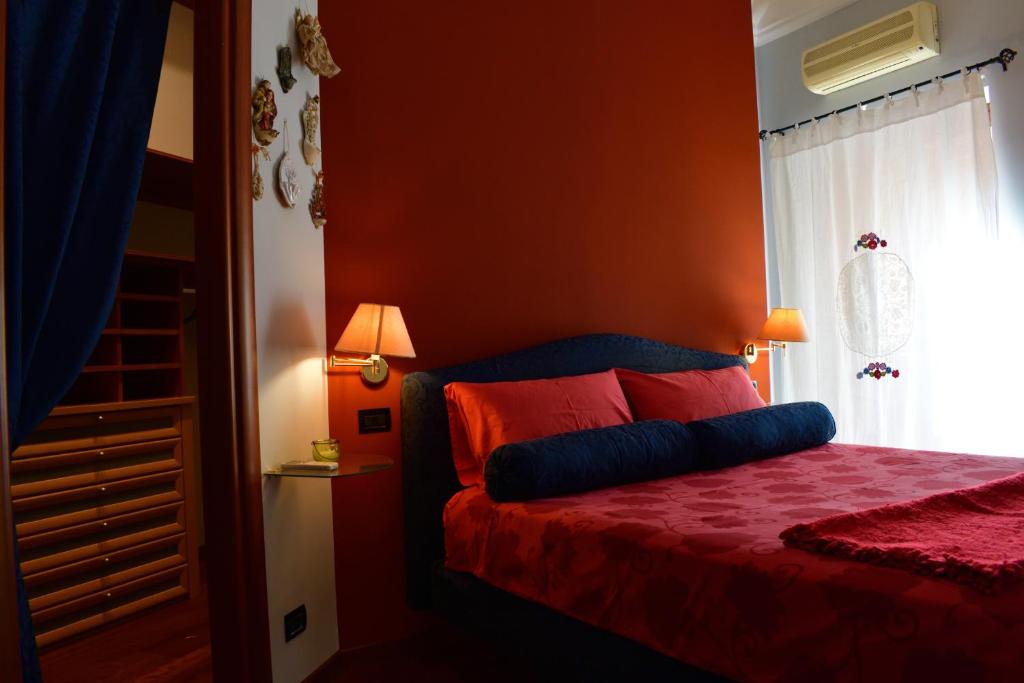 - une chambre avec des murs orange et un lit avec des draps rouges dans l'établissement B&B Le Casette Di Lù, à Agrigente