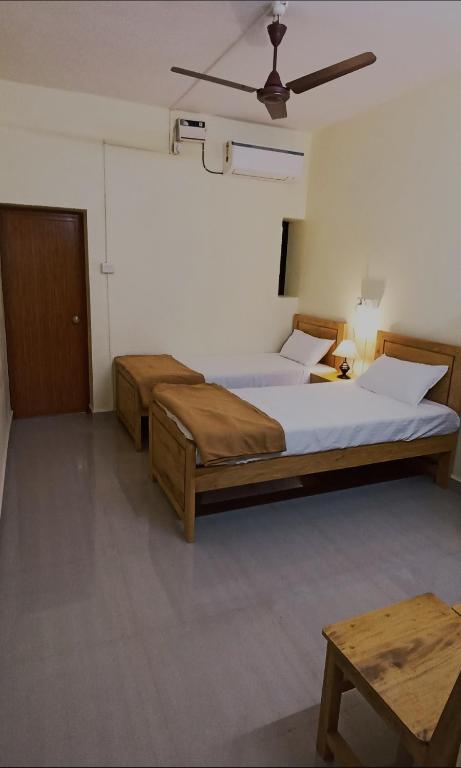 a bedroom with two beds and a ceiling at Thyme Guest House in Palolem