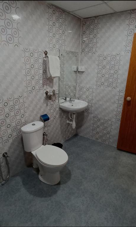 a bathroom with a toilet and a sink at Thyme Guest House in Palolem