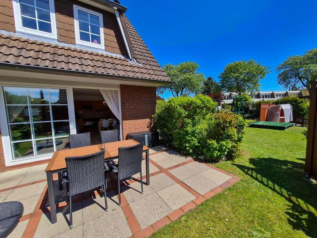 a table and chairs in the yard of a house at Ferienwohnung Siglinde in Wyk auf Föhr