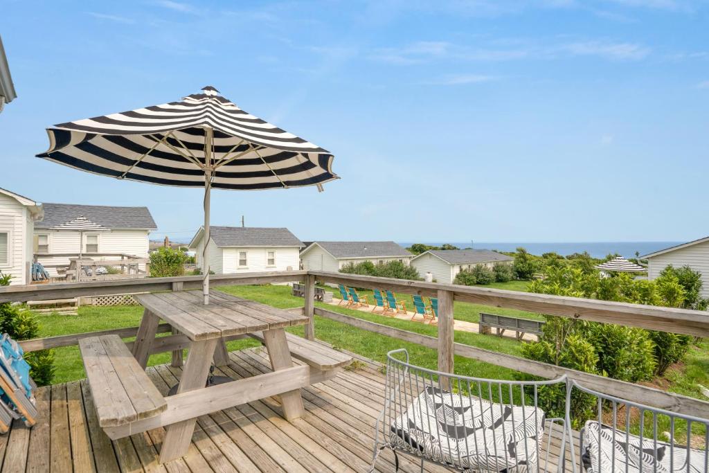 a wooden deck with a picnic table and an umbrella at Breakers Montauk in Montauk