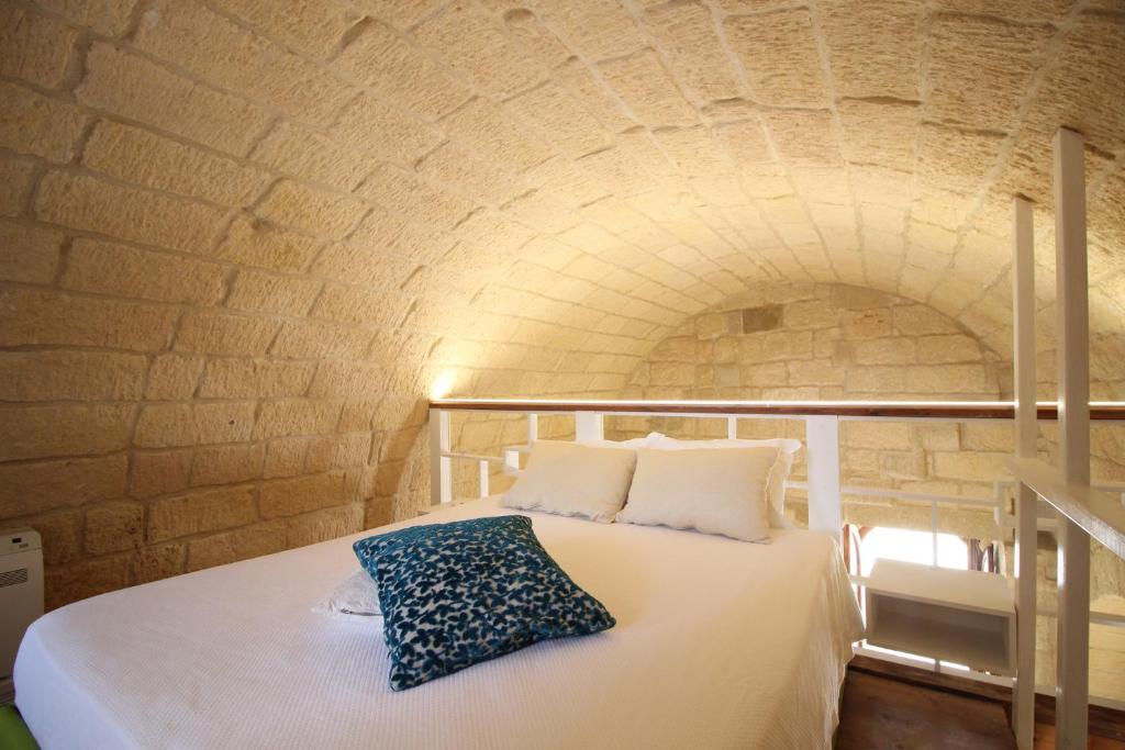 a bedroom with a bed in a brick wall at HISTORIA- Dimore Vico Ghezzi in Carpignano Salentino