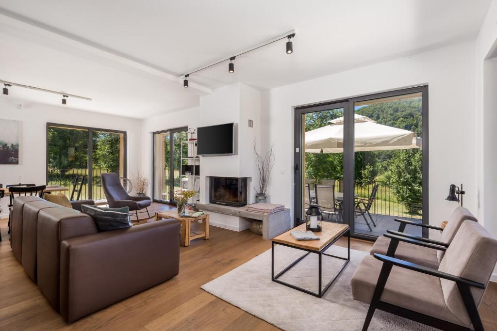 ein Wohnzimmer mit einem Sofa und einem Kamin in der Unterkunft Modern Alpine Monsalbius Chalet in Baške Oštarije