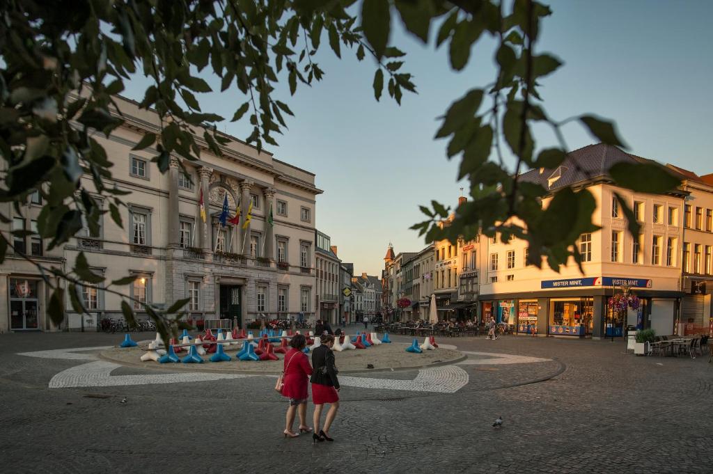 two people standing in the middle of a city street at Aalst City Center Apartment in Aalst