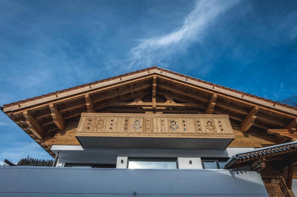 un edificio con tetto in legno e cielo sullo sfondo di Elegantes Chalet Steinbock für die Zeit zu Zweit a Jungholz