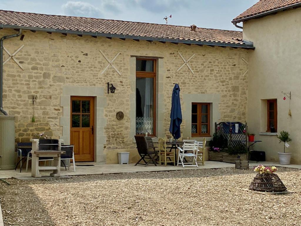 Casa de piedra con patio con mesa y sillas en Loire Escapes - Le Grenier, en Berrie
