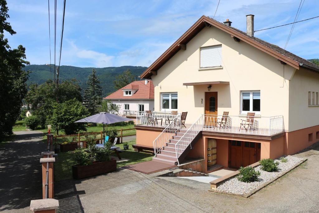 une maison avec une terrasse couverte et un balcon dans l'établissement Maison de vacances "Le Longchamp", à Osenbach