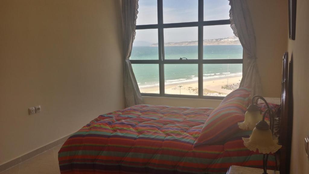 um quarto com uma janela com vista para a praia em Newcenter Suites em Tânger