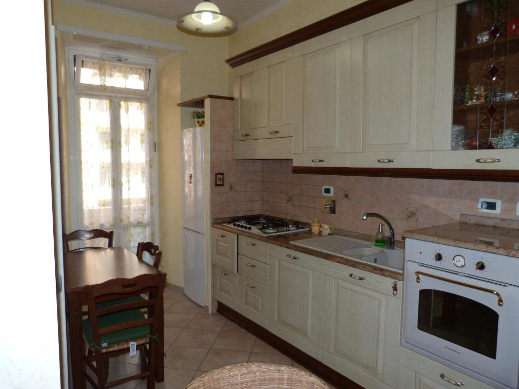 a kitchen with white cabinets and a sink and a stove at Rossanella House in Rome