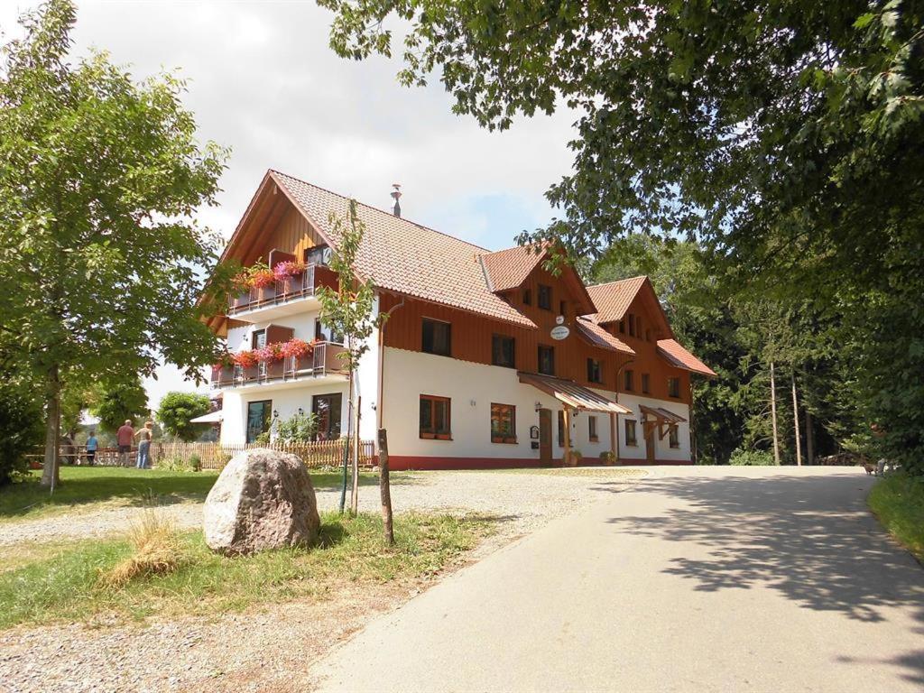 a large building with a stone in front of it at Gasthof Grüner Baum "Kongo" in Amtzell