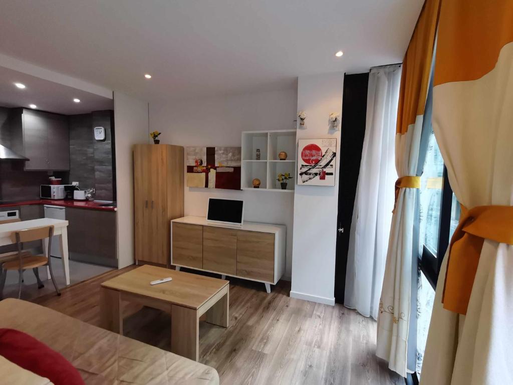 ein Wohnzimmer mit einem Tisch und einer Küche in der Unterkunft Apartamento Carreira Sada in Sada