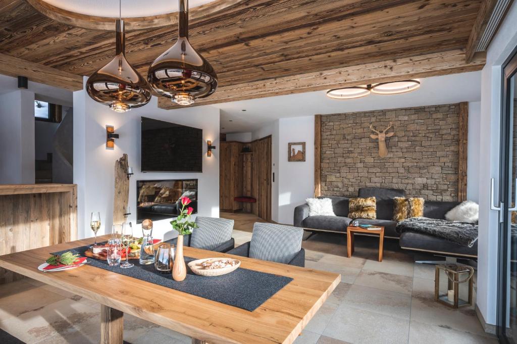 een woonkamer met een tafel en een bank bij Elegantes Chalet Steinbock für die Zeit zu Zweit in Jungholz