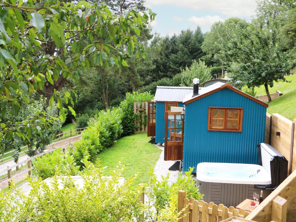 a blue shed in the middle of a garden at Little Silver Pheasant in High Bickington