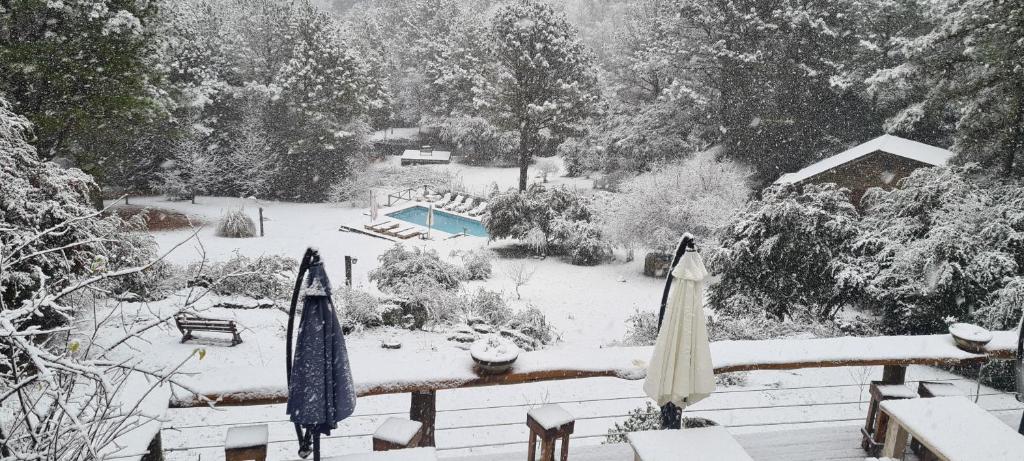 un patio cubierto de nieve con sombrillas y una piscina en Lomas de Berna en Villa Berna
