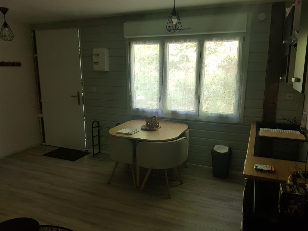 Habitación con mesa pequeña y ventana. en Appartement cosy calme à l'orée du bois, en Cornimont