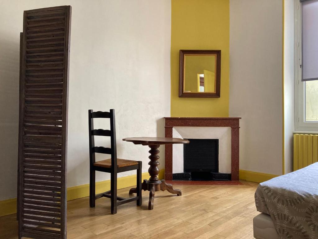 une pièce avec une table, une chaise et un miroir dans l'établissement VALS-LES-BAINS Source Sirène, à Vals-les-Bains