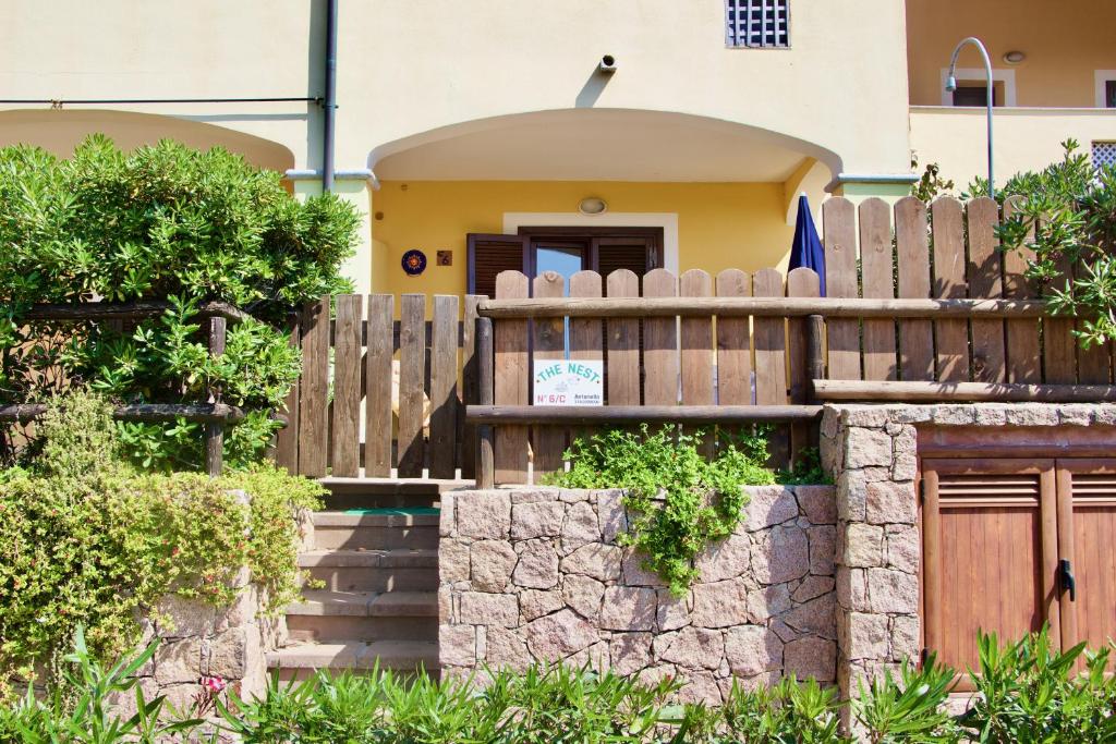 a house with a wooden fence and a stone wall at Casa THE NEST - Il Nido sul Mare in Badesi