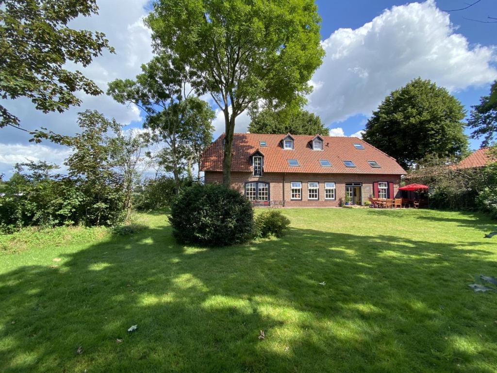 a large house with a large yard with a tree at De Meerenhoeve in Mill