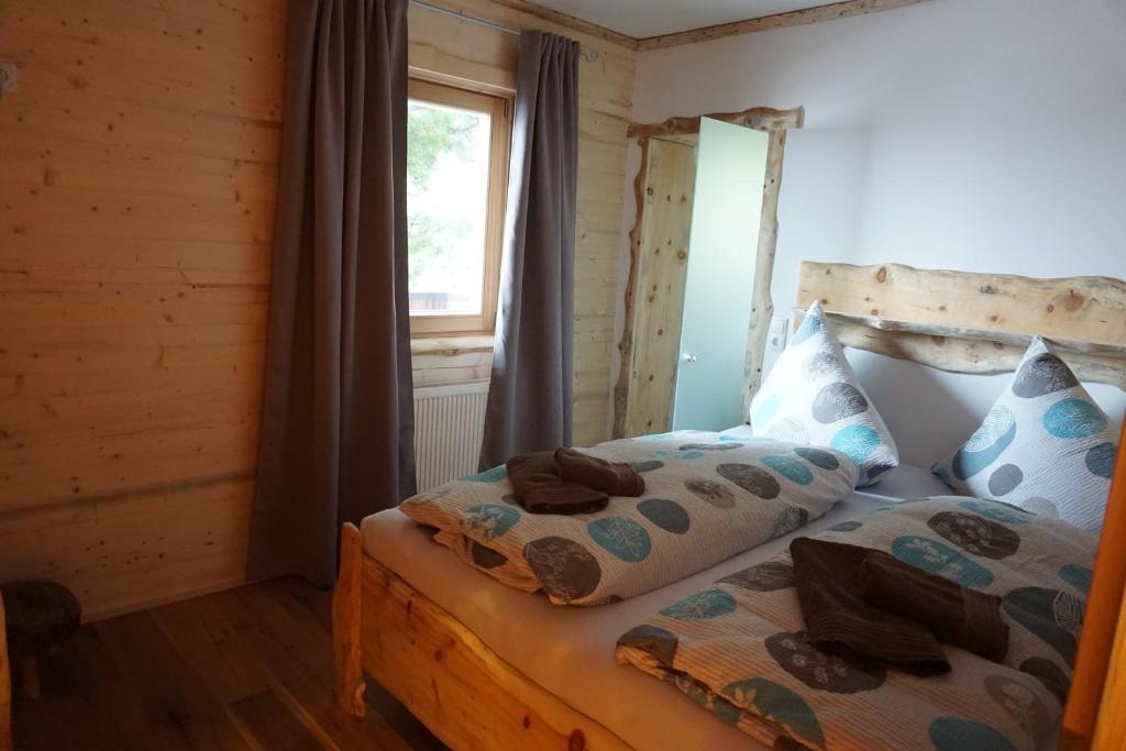 a bedroom with a bed and a window at Alpengasthof Hirschbichlalm in Zellberg