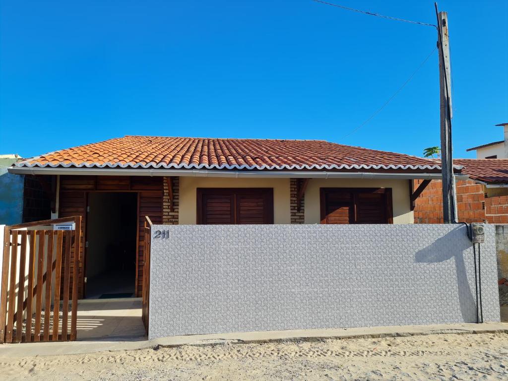 una casa con una recinzione bianca davanti di Casa de ferias - Ferienhaus - House for holiday! a Uruaú