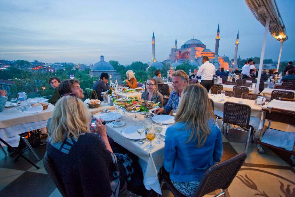 eine Gruppe von Menschen, die um einen Tisch auf einem Dach sitzen in der Unterkunft Seven Hills Hotel - Special Category in Istanbul