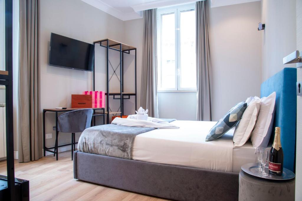 ein Schlafzimmer mit einem Bett und einem TV an der Wand in der Unterkunft AD Suites Tritone in Rom