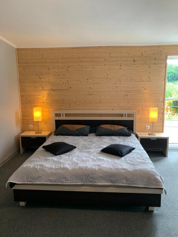 a bedroom with a large bed with two pillows on it at Pokoje Admarmal in Ściegny