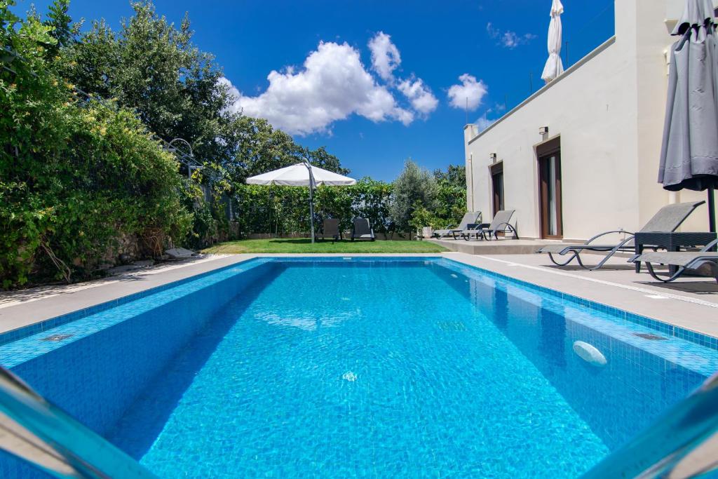a swimming pool in front of a house at Margo villa in Gállos