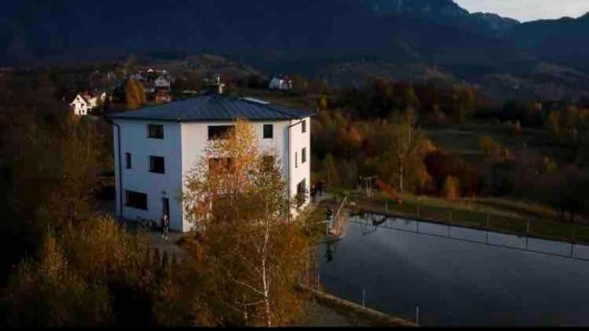 a large white building next to a body of water at Vila Panorama in Sohodol