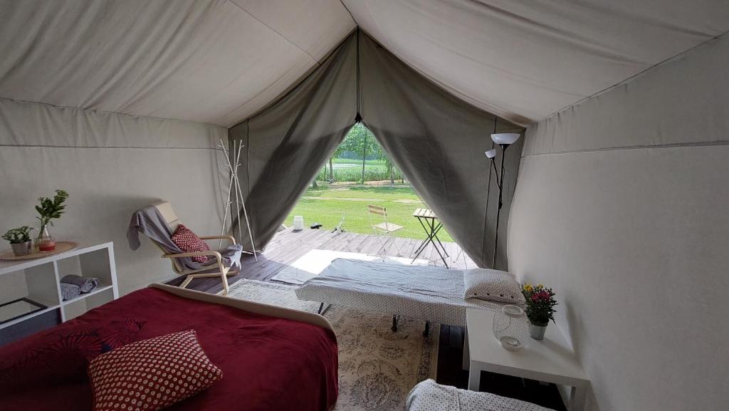 une tente avec un lit et une table. dans l'établissement Aimasas Camping, à Lielie Unguri