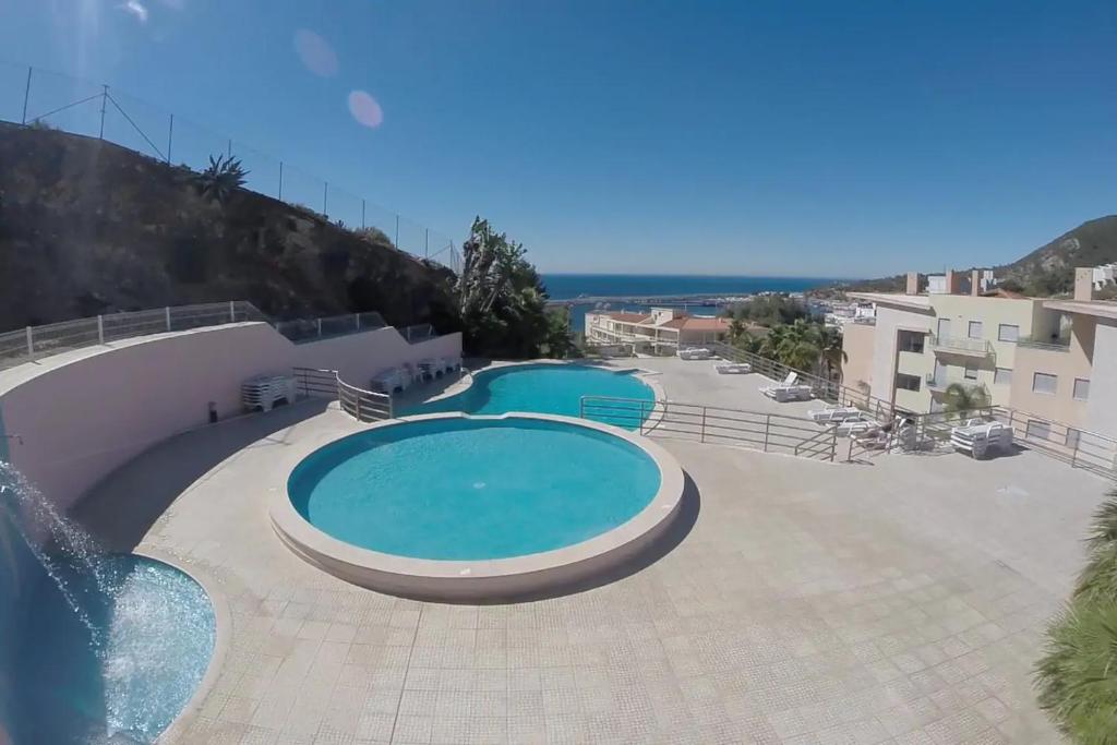 a large swimming pool in the middle of a resort at Quinta de Palames in Sesimbra