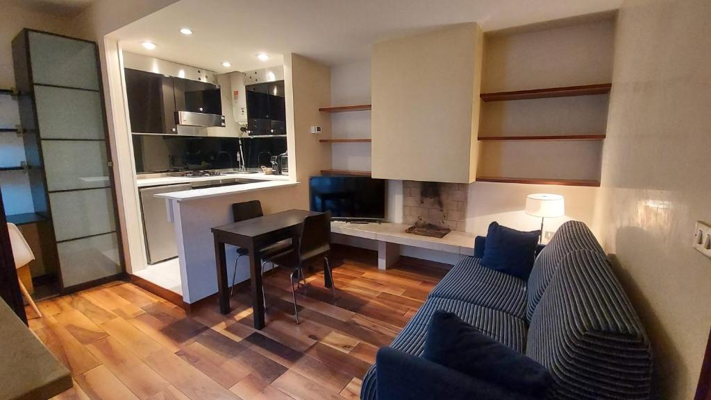 sala de estar con sofá, mesa y cocina en San Zeno Apartments, en Verona