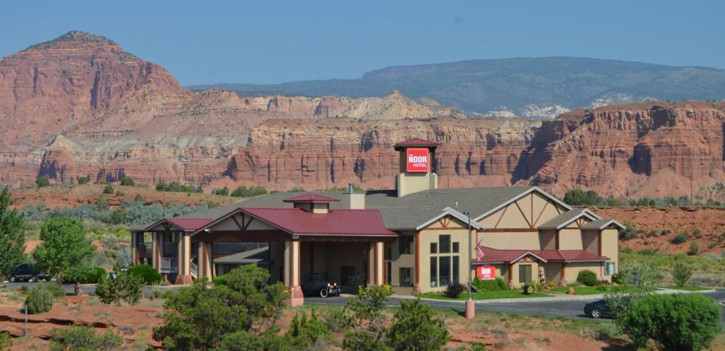 a house in the desert with mountains in the background at The Noor Hotel in Torrey