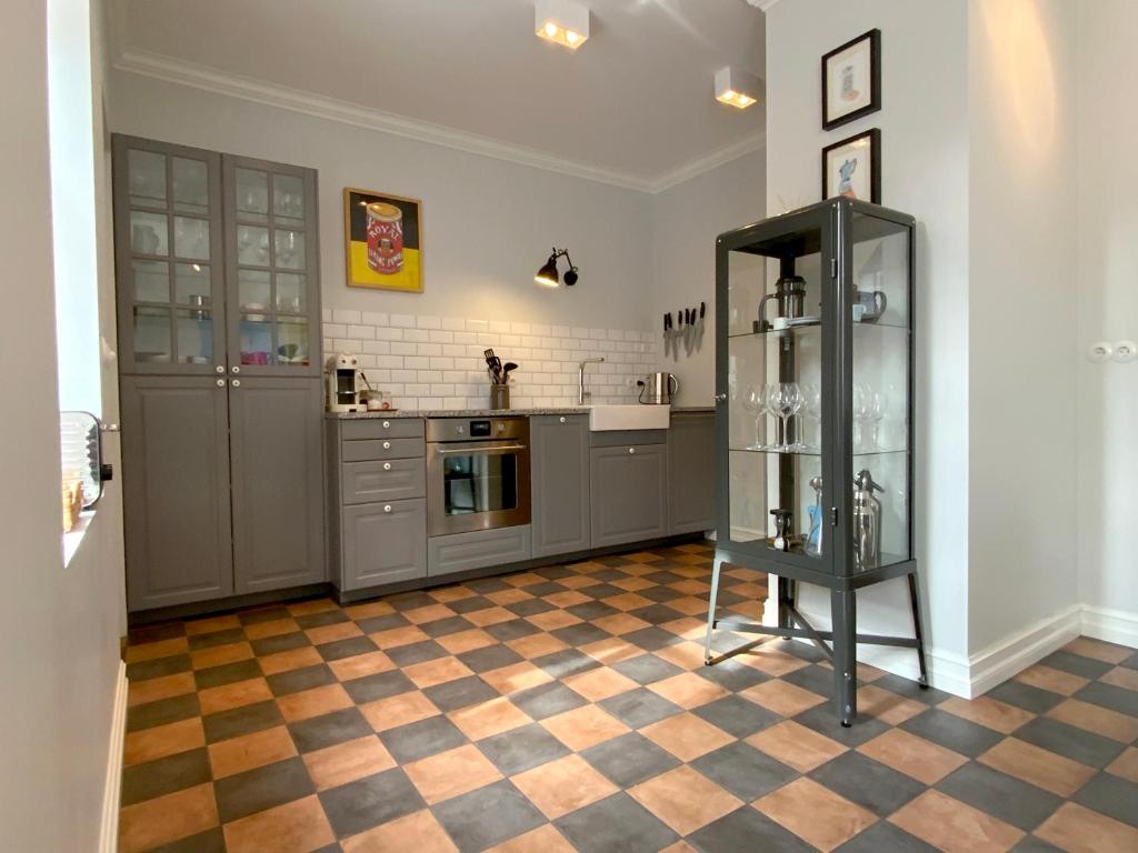 een keuken met grijze kasten en een geruite vloer bij Moon Apartments in Reykjavík