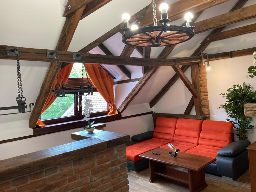 uma sala de estar com um sofá vermelho e uma mesa em Apartmanový dům 13 Podkroví 1 em Sec