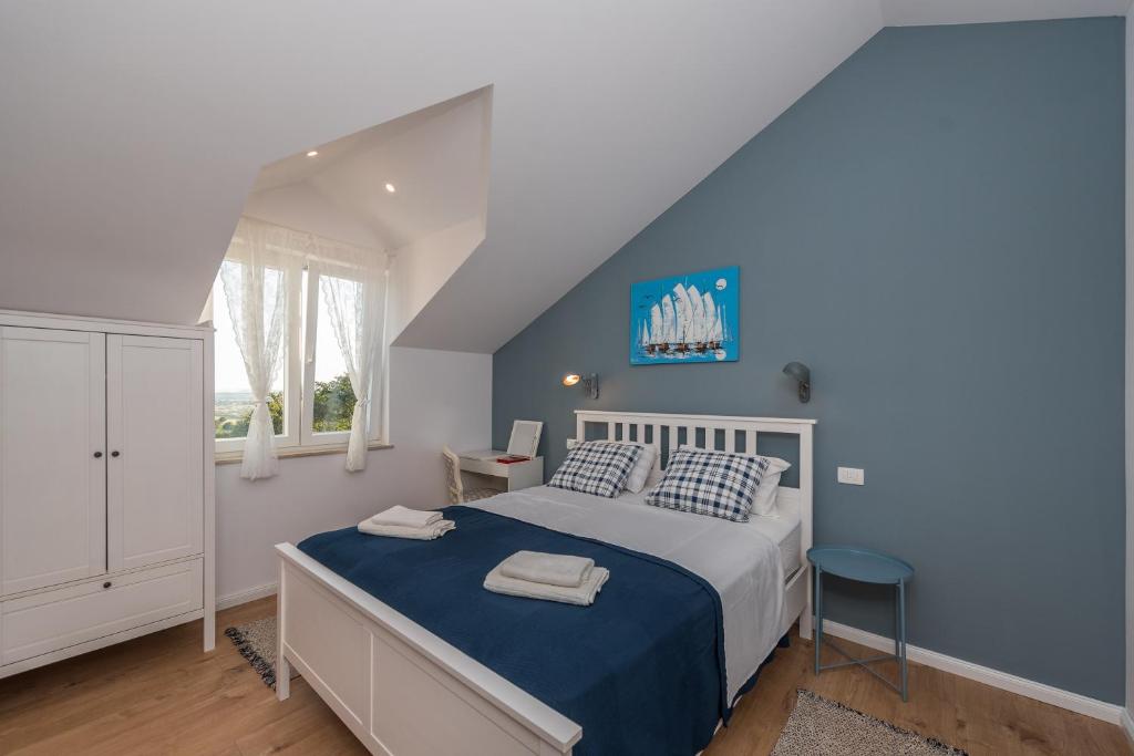 sypialnia z łóżkiem i niebieską ścianą w obiekcie Brand new Villa Cara d oro, Vrana w mieście Vrana